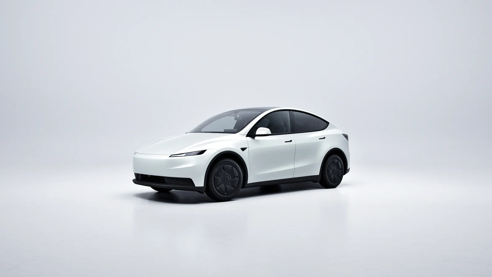 Vit Tesla Model Y snett framifrån i en ljus studio.